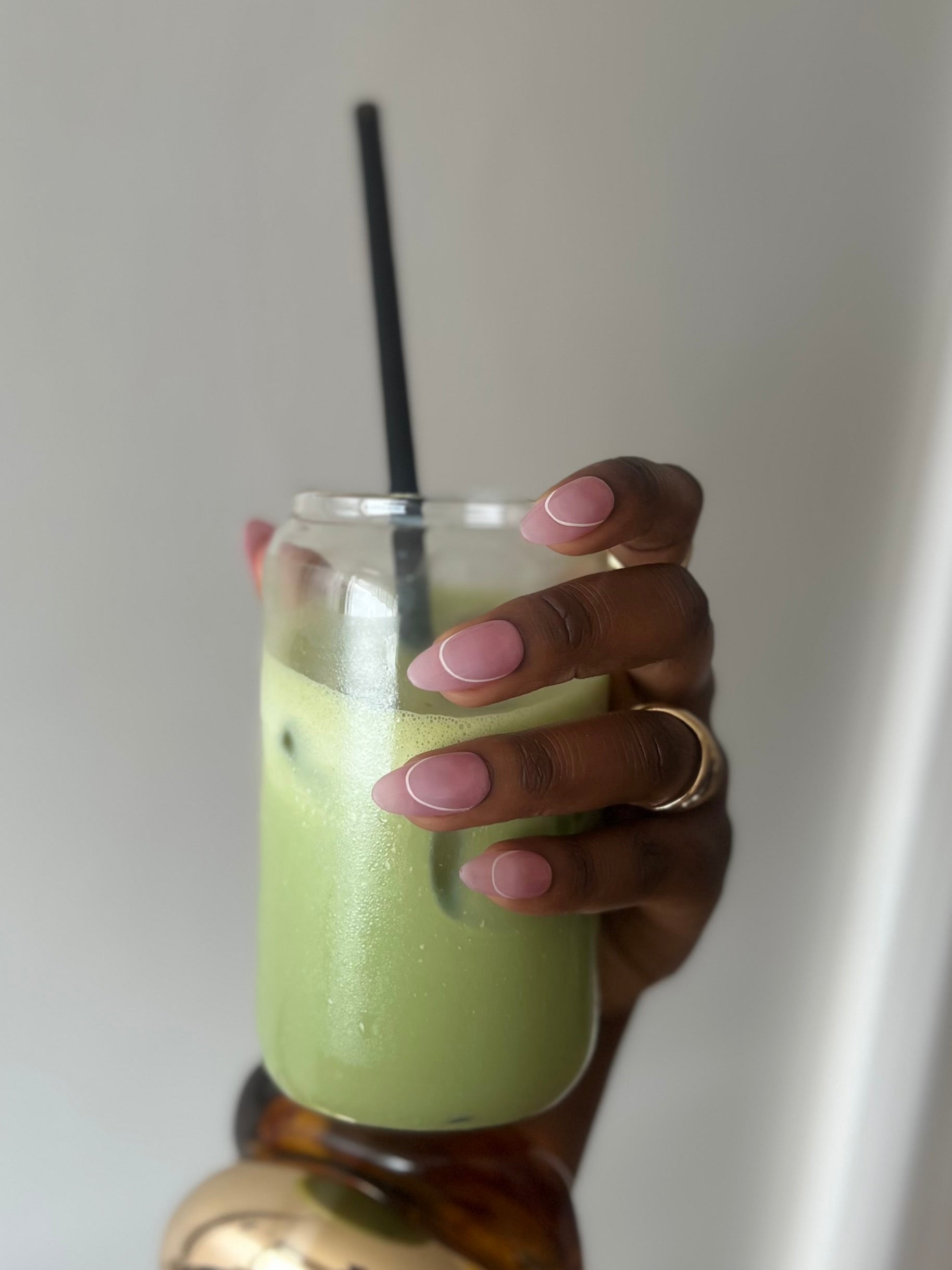 Press-on nails Essential Cherry rose nude glossy portés avec un matcha latte dans une esthétique clean girl